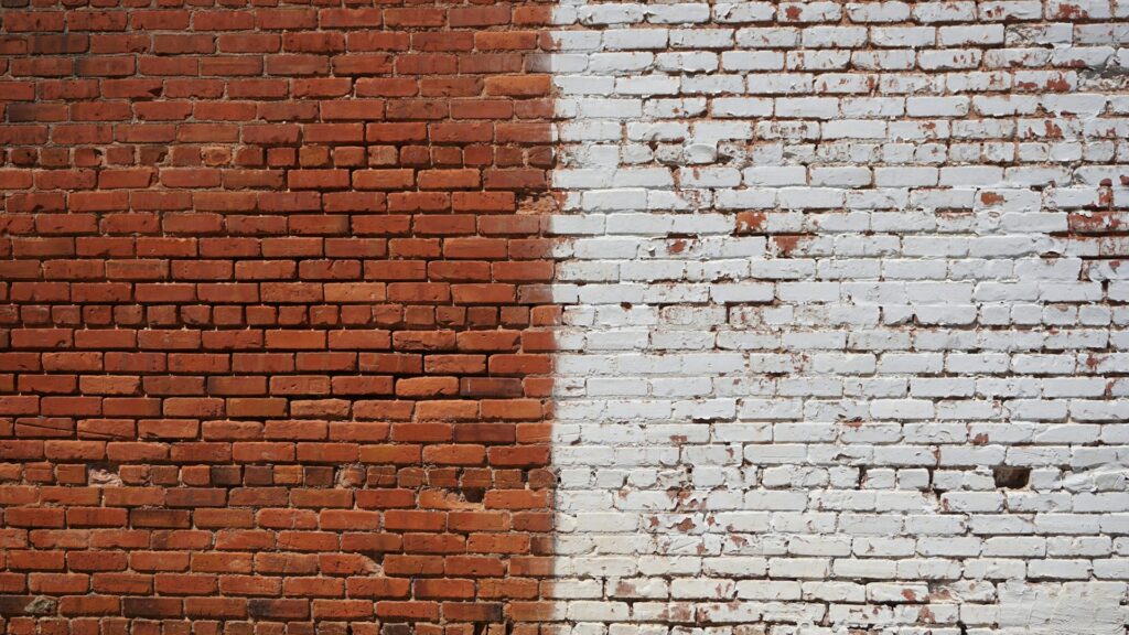 A split brick wall with red on the left and white on the right symbolizes black-and-white thinking.